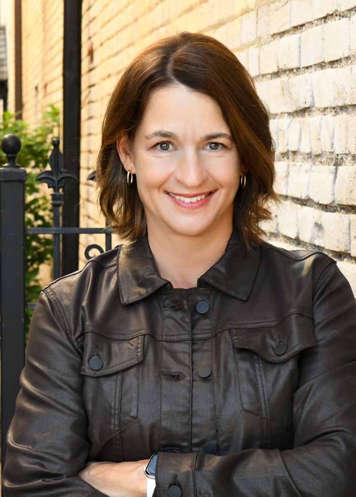 pam Pamela Kowalski in wearing a brown leather jacket